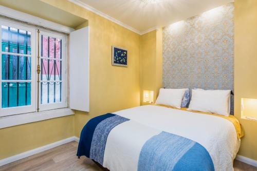 リスボンにあるBrand new and cozy Alfama Experienceのベッドルーム1室(ベッド1台、窓2つ付)