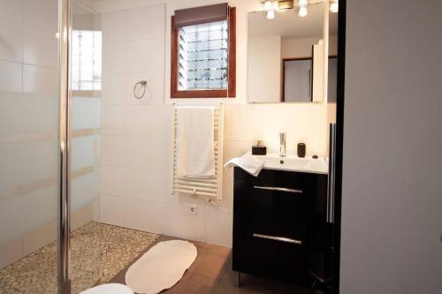un baño con lavabo y ducha en La Casita Delfin Azul, en Sa Ràpita