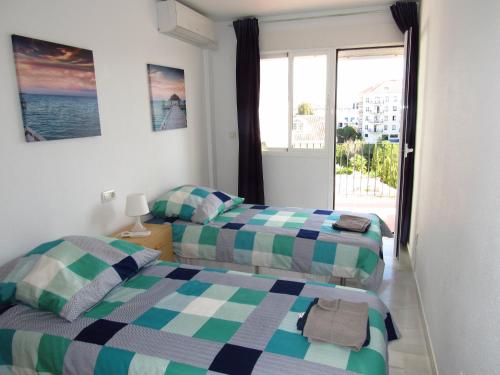 a hotel room with two beds and a balcony at Lomas de Mena in Benalmádena