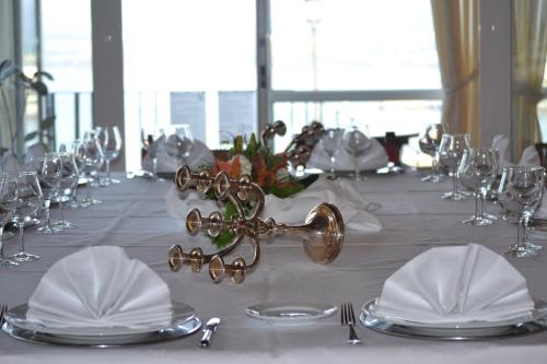 a long table with white linen and silver plates and glasses at Parador de Ribadeo in Ribadeo