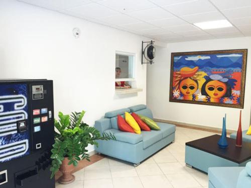a living room with a blue couch and a video game at Levimar Guest House in Levittown