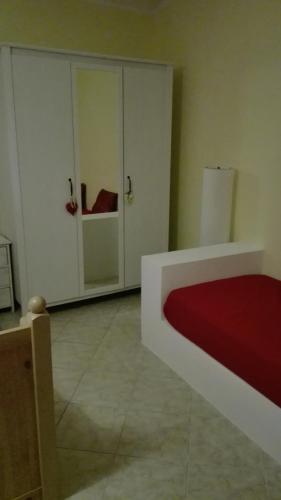 a room with two white cabinets and a red bed at Sally's House in Venaria Reale