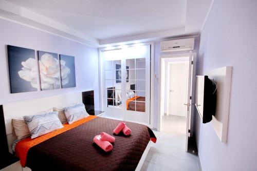 プラヤ・デ・ラス・アメリカスにあるModern sea view apartment near Playa Las Américas beachのベッドルーム1室(ピンクのスリッパ2枚付)