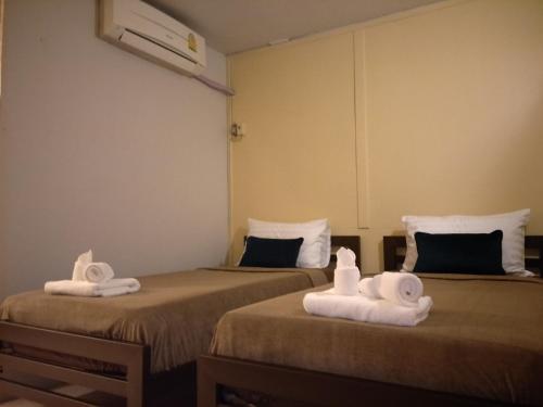 two beds with towels on them in a room at BeauBo Beach in Baan Tai