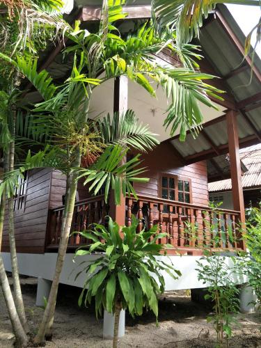 a wooden house with trees in front of it at BeauBo Beach in Baan Tai