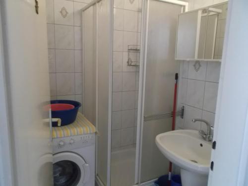 La salle de bains est pourvue d'un lave-linge et d'un lavabo. dans l'établissement Livia Apartman, à Balatonföldvár
