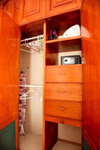 a closet with a wooden cabinet with a microwave at Departamentos K&B in Playa del Carmen