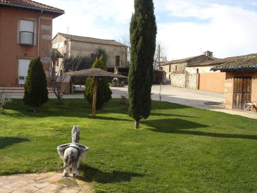 a statue of a dog standing in a yard at Posada Tresmentiras in Aldeanueva del Camino
