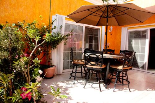 a patio with a table and chairs and an umbrella at Departamentos K&B in Playa del Carmen