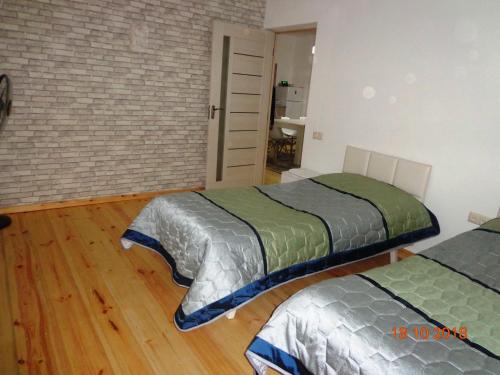 two beds in a room with wooden floors at Artson B&B Vagharshapat in Vagharshapat