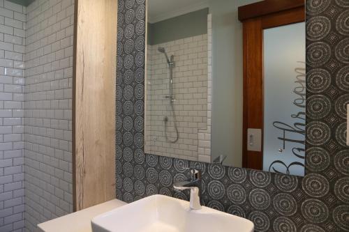 a bathroom with a white sink and a mirror at Namib Guesthouse in Swakopmund