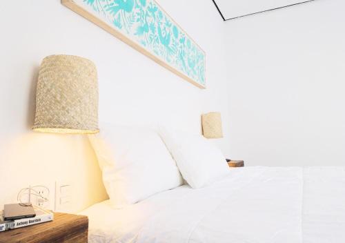 a bedroom with a white bed and a lamp at Hotel Mamá Carlota in Querétaro