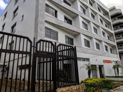 a white building with a fence in front of it at Apartamento Cabo Frio in Cabo Frio