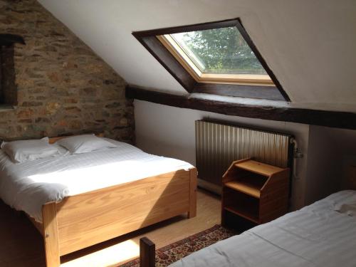 a attic bedroom with two beds and a window at Vennhaus 33 pers in Waimes