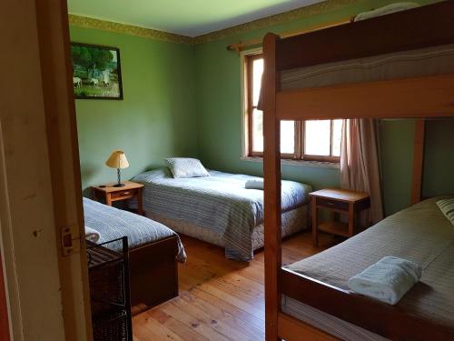 1 dormitorio con 2 literas y ventana en Mavidahue en llifen
