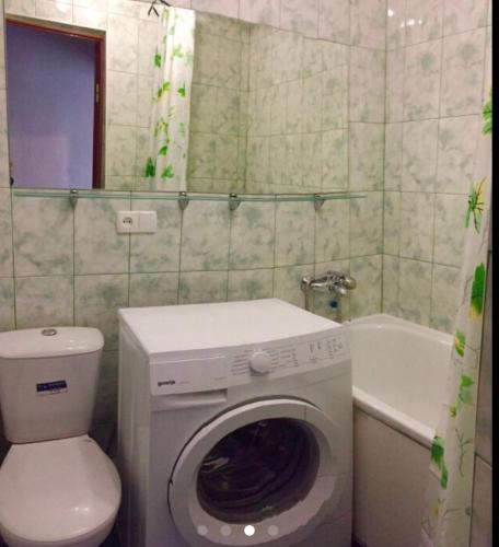 La salle de bains est pourvue d'un lave-linge, de toilettes et d'une baignoire. dans l'établissement Apartment Shevchenka 154, à Nikopol