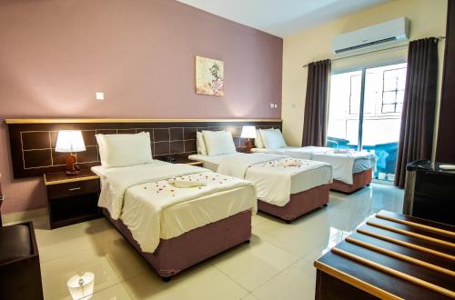 a hotel room with two beds and a window at Mutrah Hotel in Muscat