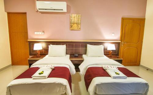 a hotel room with two beds in a room at Mutrah Hotel in Muscat