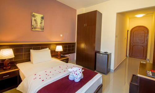 a bedroom with a bed with a stuffed elephant on it at Mutrah Hotel in Muscat