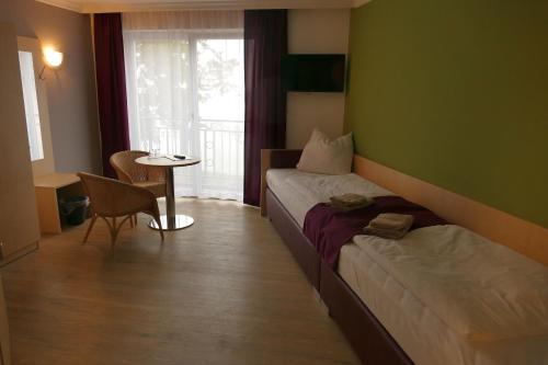 a hotel room with a bed and a table and a window at Seehotel Bad Kleinen in Bad Kleinen