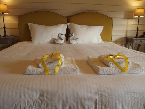 a bed with two towels with bows on it at Ktima Noosfera Wellness & Retreat Center in Nees Vrisoules