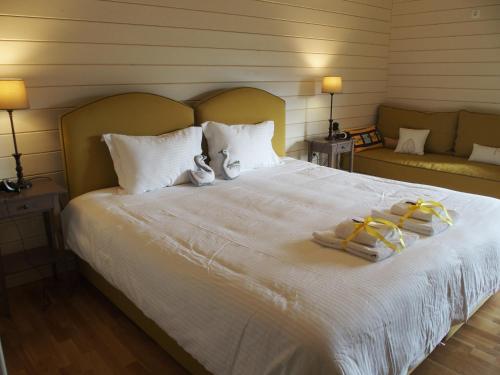 a bedroom with a large white bed with towels on it at Ktima Noosfera Wellness & Retreat Center in Nees Vrisoules
