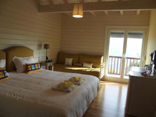 a bedroom with a large bed and a balcony at Ktima Noosfera Wellness & Retreat Center in Nees Vrisoules