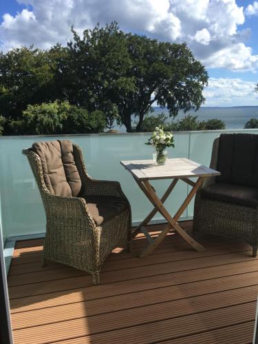 a patio with two chairs and a table on a deck at Ostseeblick Sassnitz in Sassnitz