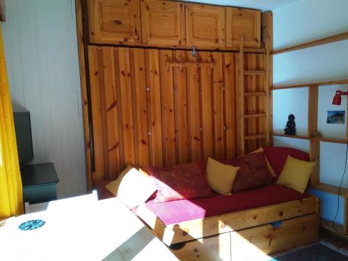 um sofá num quarto com uma parede de madeira em studio isabelle em Saint-Chaffrey