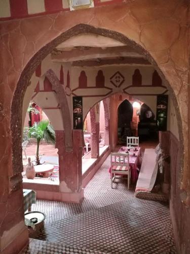 an archway in a building with a table and chairs at Riad Berbère Boutaghrar in Bou Drarar