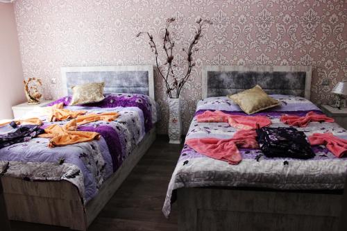 two beds sitting next to each other in a bedroom at Golden Way in Tbilisi City