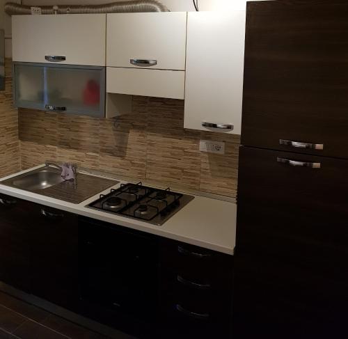 a kitchen with a stove top oven next to a sink at Le Antiche Mura in Sassari