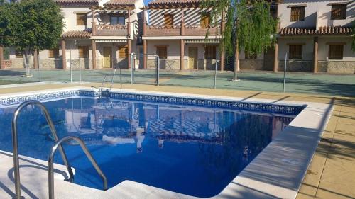 a large blue swimming pool in front of a building at Apartamentos Las Colinas in Vélez-Málaga