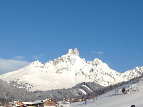a snow covered mountain in the distance with houses in the foreground at Haus Waldrast in Filzmoos