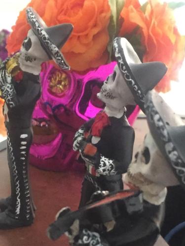 two figurines of skeletons standing in front of a skull at Residence Las Trojes Cdmx in Mexico City