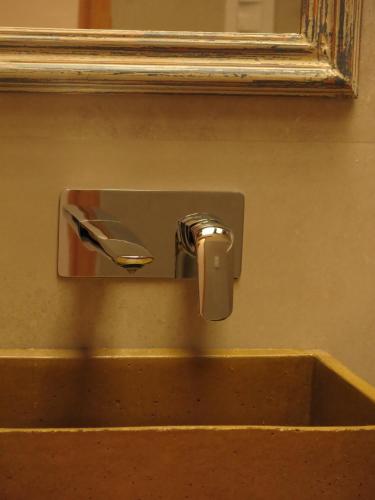 a sink with a faucet in front of a mirror at Casatilcara Cabañas in Tilcara