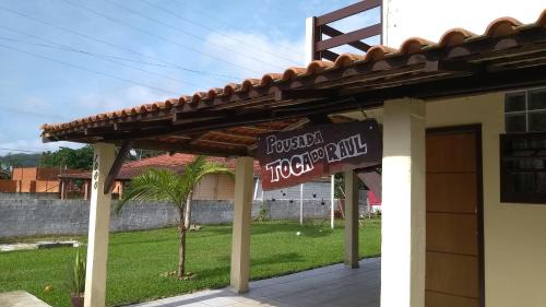 a sign for a hotel in front of a building at Pousada Toca Do Raul in Itapoa