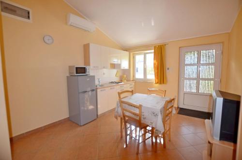 a kitchen and dining room with a table and a refrigerator at Apartments Zora in Rakalj