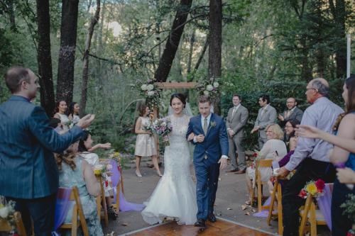 une mariée et un marié se promenant dans l'allée à leur mariage dans l'établissement Junipine Resort, à Sedona