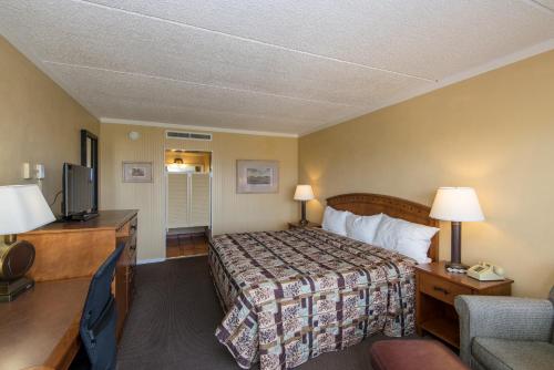 Habitación de hotel con cama y TV en Landmark Lookout Lodge, en Tombstone