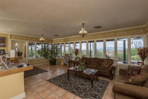 a living room filled with furniture and windows at Landmark Lookout Lodge in Tombstone