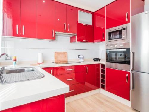 a kitchen with red cabinets and a stainless steel refrigerator at apartamento tenerife in Icod de los Vinos