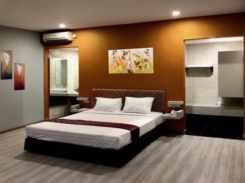 Hotel Sinar 1 في Sedati: غرفة نوم بسرير كبير في غرفة