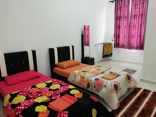 a bedroom with two beds and a bedspread on the floor at Faeyz Homestay Melaka in Melaka