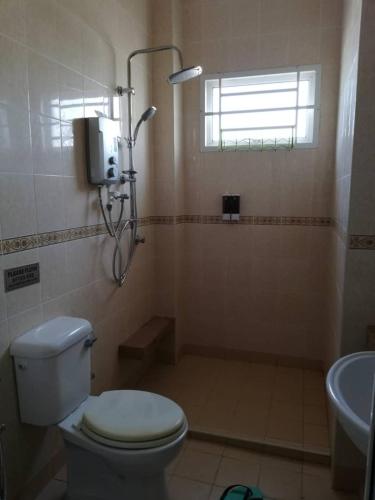 a bathroom with a toilet and a shower and a sink at Faeyz Homestay Pertam Jaya in Malacca
