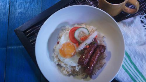 un plato de desayuno con huevos y salchichas en Villa Elita, en Sudipen