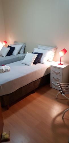 dos camas sentadas una al lado de la otra en un dormitorio en Conforto, praticidade e seguranca!, en Curitiba