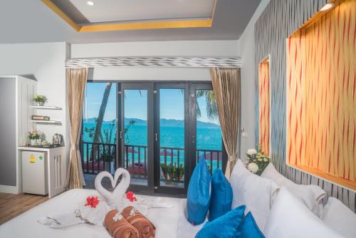 a room with a bed with a view of the ocean at The Florist Resort in Mae Nam