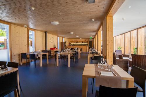 um restaurante com paredes e mesas e cadeiras de madeira em Familienhotel Campagna em Frasco