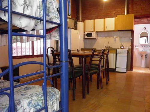Habitación con litera, mesa y sillas en Cabañas Ranquil Luncay en Uspallata